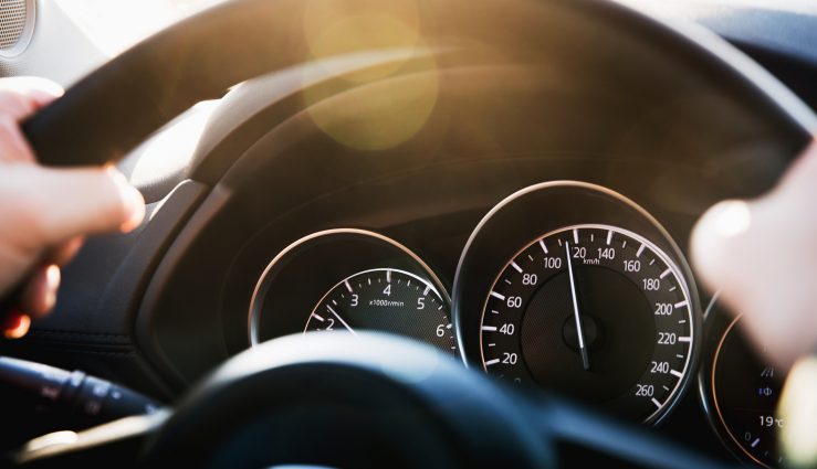Speedometer of a car close-up, with the arrow frozen at a speed of 120 km/h. Details and interior of a black luxury car.